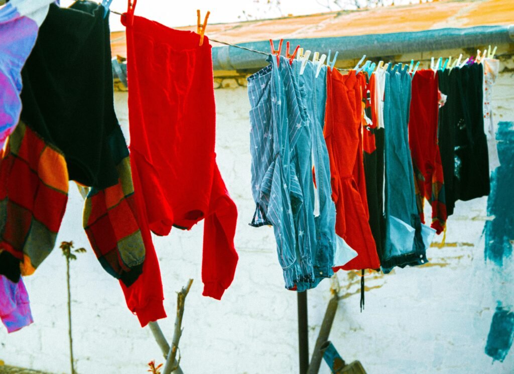 Colorful clothes drying on a clothesline under the sun, creating a lively outdoor scene.